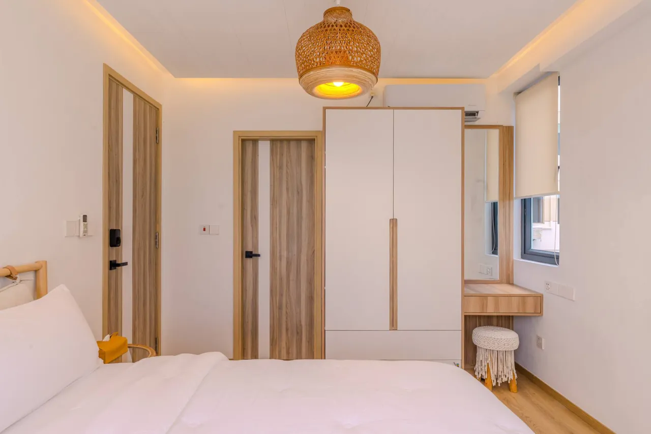 Bedroom with a white wardrobe, a rattan pendant light and a dressing table