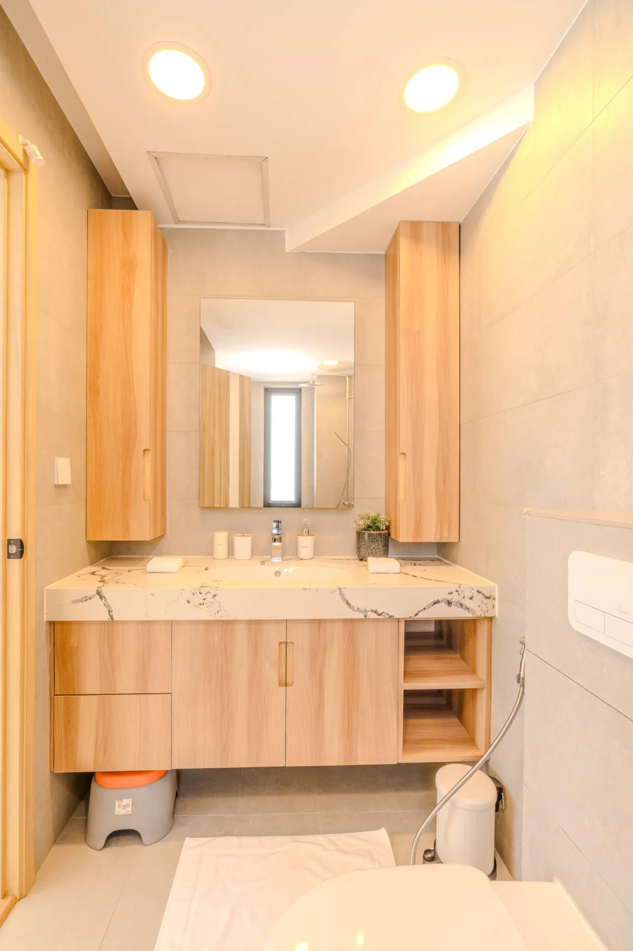 Guest bathroom with a marble-topped vanity and mirrored timber cabinets